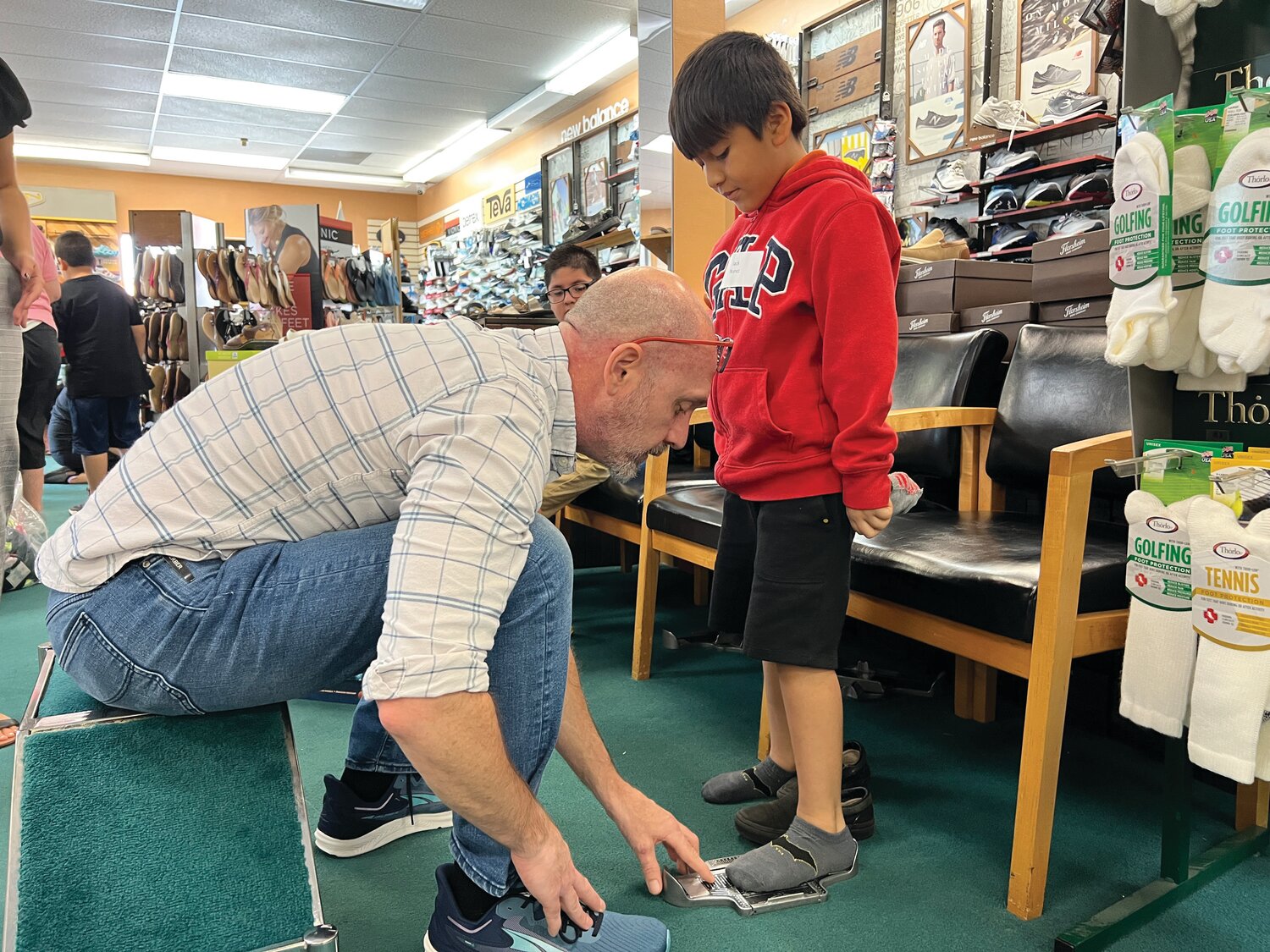 Jack, a student in Guadalupe Center’s Summer Enrichment Program, has his feet professionally measured before picking out a new pair of shoes.